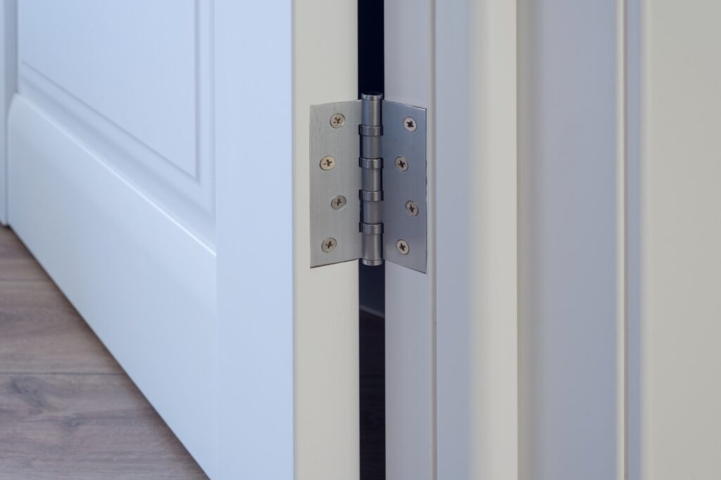 Metal chrome hinged hinges on a white interior door