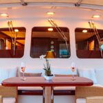 Wooden table with two champagne glasses on the yacht